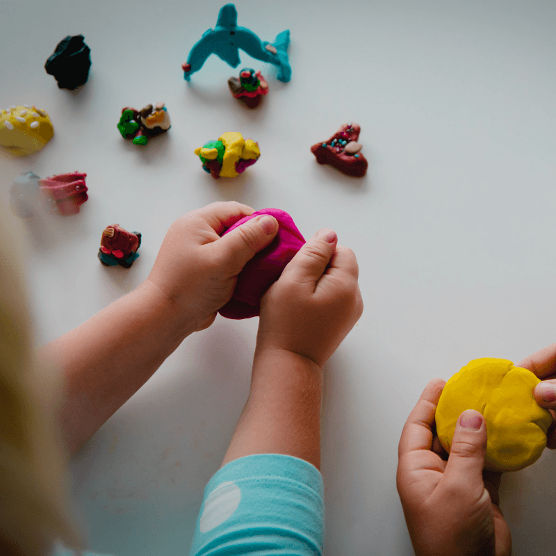 Children playing with colorful clay and figurines at Miami Children's Museum