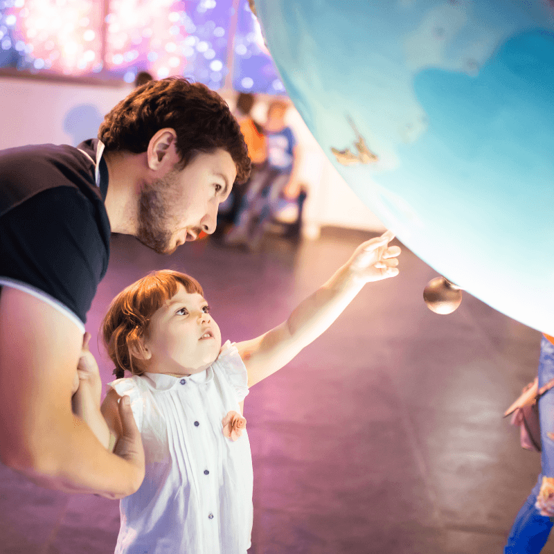 Father and daughter exploring a globe exhibit at the Frost Science Museum
